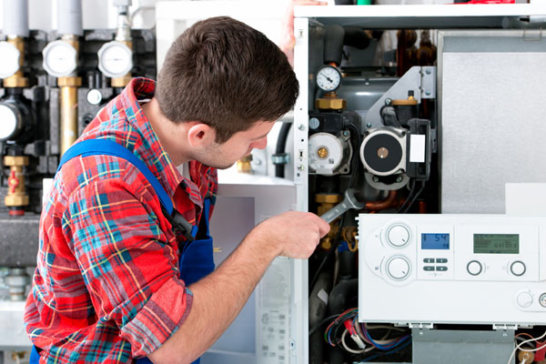 HVAC technician inspecting and repairing boiler controls in Loveland