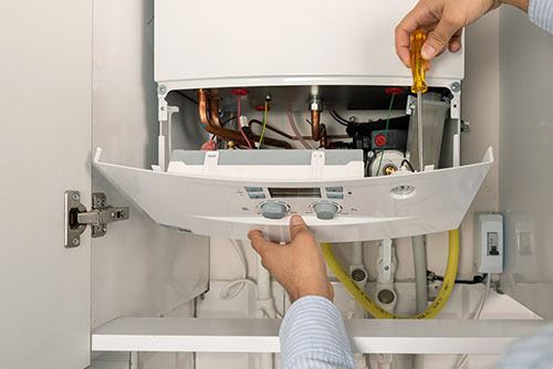 HVAC technician repairing an indoor boiler in Loveland