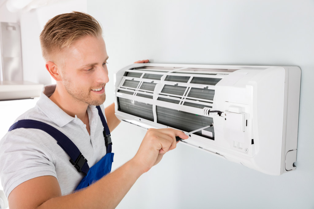HVAC technician performing ductless air conditioning maintenance in Loveland