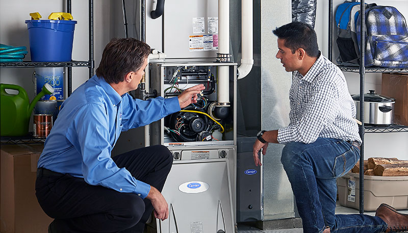 HVAC technician evaluating a furnace for repair or replacement in Loveland