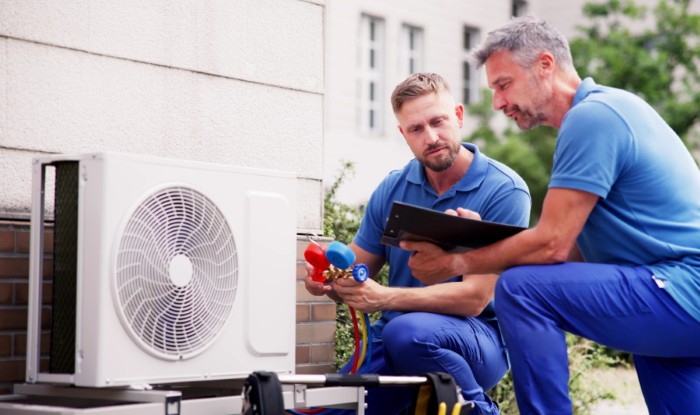 HVAC technicians installing an outdoor air conditioning unit in Loveland
