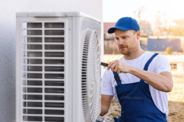 HVAC technician servicing an outdoor air conditioning unit in Loveland