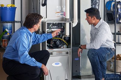 HVAC technician explaining furnace repair and maintenance to a homeowner in Loveland, CO