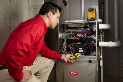Heating and air conditioning technician servicing an indoor furnace in Loveland, CO